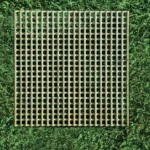 Square planed trellis against green hedge